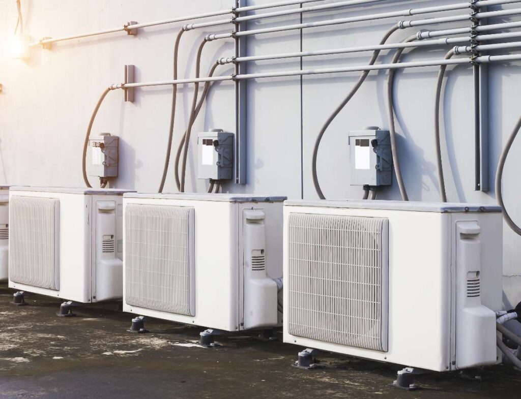 An exterior wall of large air conditioning units at a commercial or industrial building providing cooling services on the Lower Mainland BC